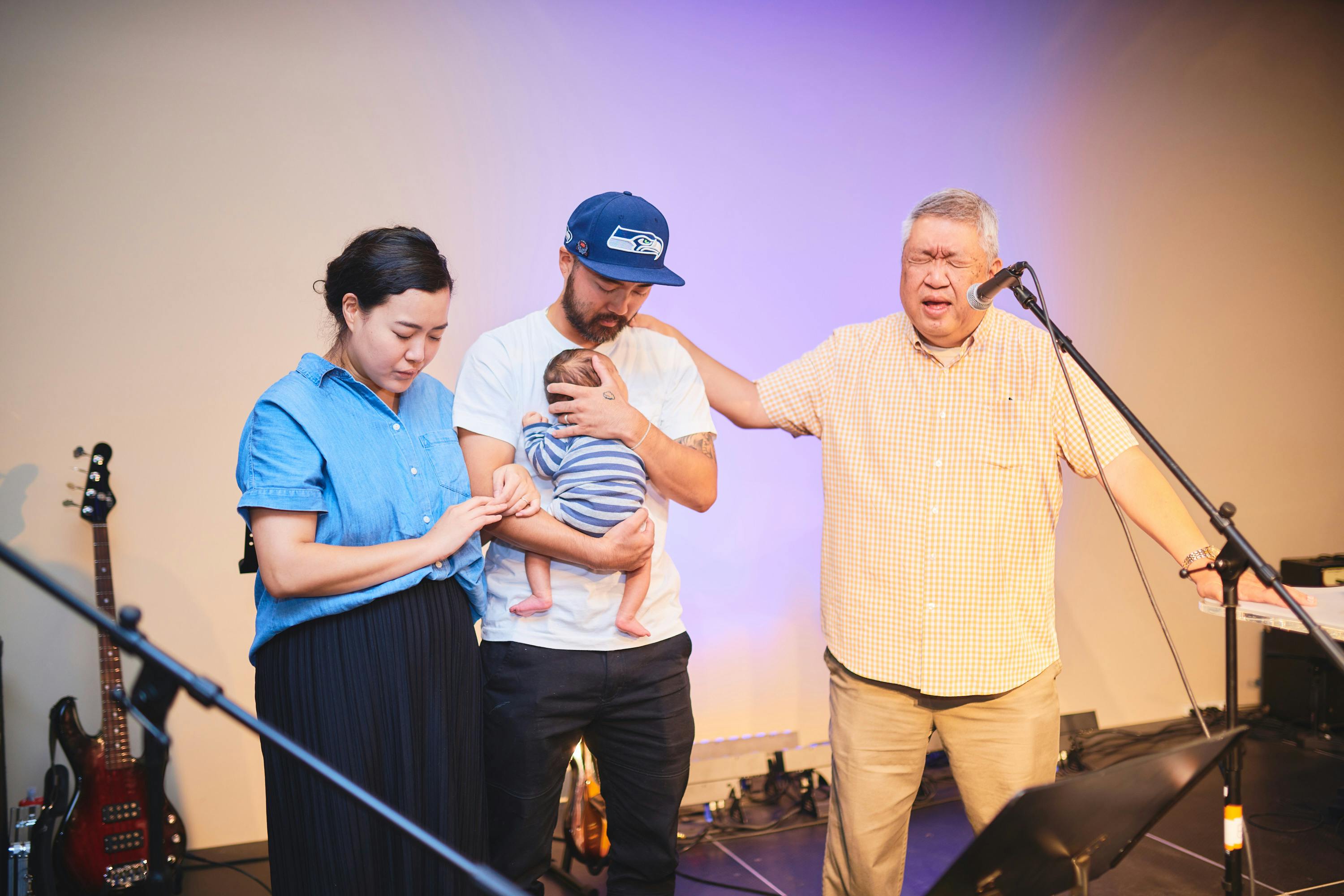 pastor praying with wife, husband and child